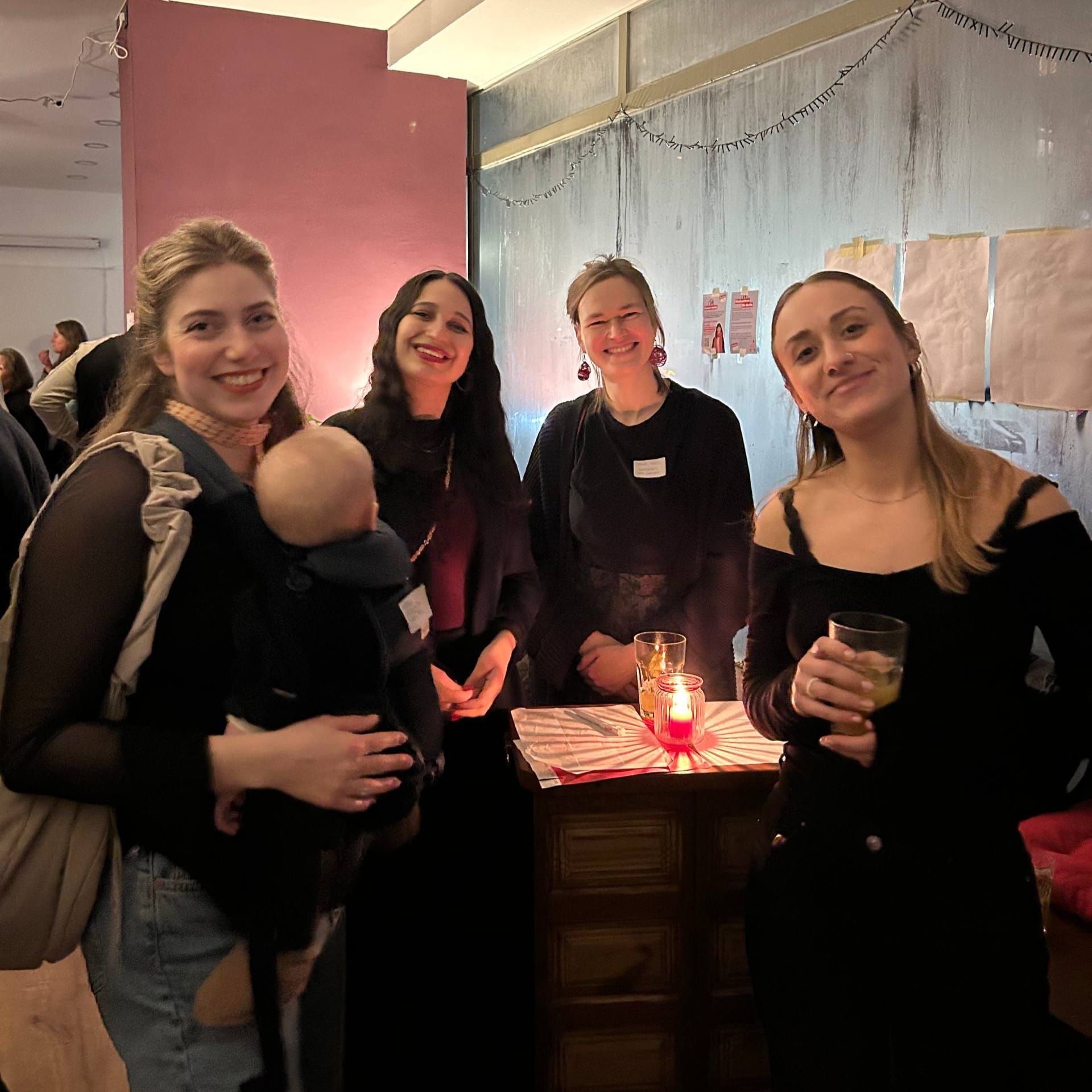 Vier Frauen und ein Baby stehen im Wahlkreisbüro an eim Tisch mit Kerzen und lachen in die Kamera